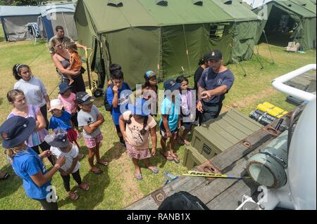 Royal New Zealand Navy Able Diver Hayden Shapcott, assigned to the Royal New Zealand Navy Littoral Warfare Unit, explains the functions of a dive chamber to a group of children during Exercise Fulcrum in Bland Bay, New Zealand, Feb. 17, 2017. Exercise Fulcrum is a combined-joint exercise that integrates U.S. Navy Sailors and Marines from explosive ordnance disposal mobile units with service members from the Royal New Zealand Navy and the Royal Australian Navy. Stock Photo