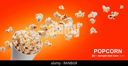 Popcorn in cardboard box, isolated on red background Stock Photo