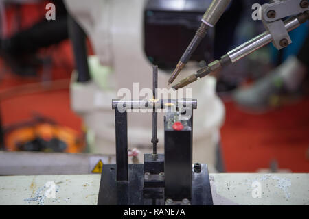 Robotic arm TIG welding machine welding steel workpiece Stock Photo