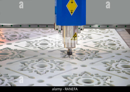 CNC cutting machine cutting pattern of flower on plastic sheet Stock Photo