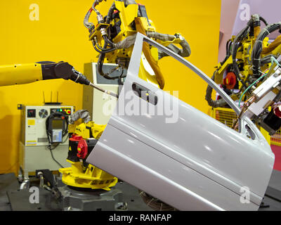Robot arm demonstrate spot welding car door Stock Photo