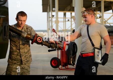 U.S. Air Force Airman 1st Class Zachary Rogers, 20th Aircraft Maintenance Squadron tactical aircraft maintainer, right, passes a fuel hose to Airman 1st Class Alec Hyman, 20th Logistics Readiness Squadron fuels distribution operator, left, at Shaw Air Force Base, S.C., Feb. 28, 2017. The hose allows Jet A fuel to flow from a R-11 refueling truck into F-16CM Fighting Falcons, filling an empty jet equipped with external tanks in approximately four minutes. Stock Photo