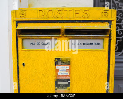 Le Touquet, France - December 2017: Bright yellow metal postbox from the French National Post with a dedicated compartment for Pas De Calais region Stock Photo