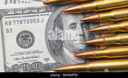bullets close-up lie on the bills of 100 dollars. Concept of copy space currency and national defense Stock Photo