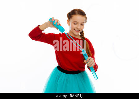 Joyful creative pleasant girl blowing soap bubbles Stock Photo