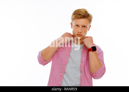Serious nice young man touching his collar Stock Photo