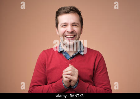 Adult good looking european man laughing, holding hands together and smiling broadly, having fun Stock Photo