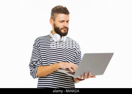 Serious young man looking at his laptop screen Stock Photo