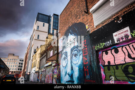 A moody scene of the back alley of Cropper Street, Liverpool with a John Lennon mural and other graffiti. Stock Photo