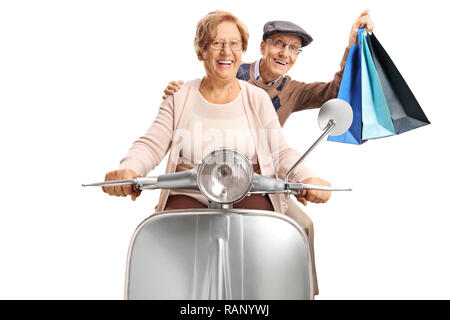 Cheerful senior couple with shopping bags riding a vintage scooter isolated on white background Stock Photo