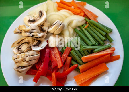 A plain head on shot of Raw uncooked but prepared 5 A Day vegetable portions on one plate Stock Photo