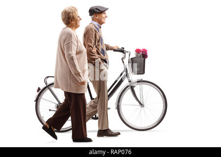 Full length shot of a senior couple walking with a bicycle isolated on white background Stock Photo