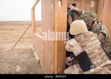 A British army engineer assist Iraqi security forces soldiers place a controlled explosives charge on a door during breach and entry training at Camp Taji, Iraq, Feb. 23, 2017. ISF participated in the Junior Leaders Course led by Coalition forces designed to enhance basic combat skills in support of Combined Joint Task Force – Operation Inherent Resolve, the global Coalition to defeat ISIS in Iraq and Syria. Stock Photo