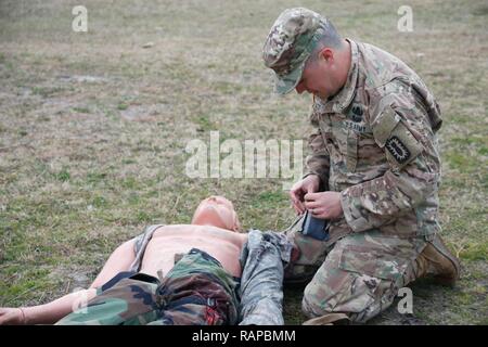 U.S. Army Spc. Arturo Lovato, assigned to 722nd Ordnance Company (EOD), 192nd Ordnance Battalion (EOD), 52nd Ordnance Group (EOD), prepares to treat a simulated casualty during the Renegade Fury competition at Fort Bragg, N.C., Feb. 28, 2017. The scenario evaluated competitors on their ability to provide tactical combat casualty care while under stress. Stock Photo