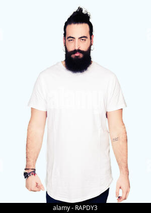 Young hipster man with long hair and beard wearing casual white t-shirt skeptic and nervous, frowning upset because of problem. Negative person. Stock Photo