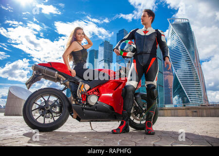 Portrait in full growth, young couple on a sports bike on the background of the city skyline Stock Photo