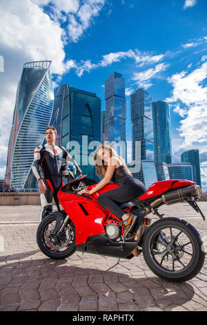 Portrait in full growth, young couple on a sports bike on the background of the city skyline Stock Photo