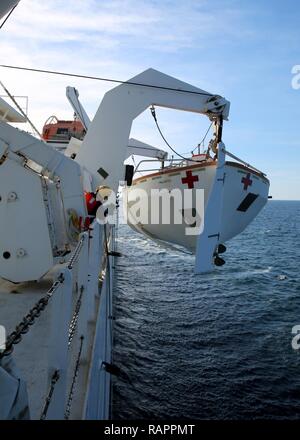 ATLANTIC OCEAN (February 21, 2017)--Civil Service Mariners attached to Military Sealift Command's hospital ship USNS Comfort (T-AH 20) secure a lifeboat after an abandon ship drill aboard the vessel, Feb. 21. Comfort was at sea for its Comfort Exercise (COMFEX). Stock Photo