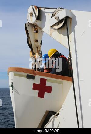 ATLANTIC OCEAN (February 21, 2017)--Civil Service Mariners attached to Military Sealift Command's hospital ship USNS Comfort (T-AH 20) secure a lifeboat after an abandon ship drill aboard the vessel, Feb. 21. Comfort was at sea for its Comfort Exercise (COMFEX). Stock Photo