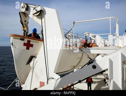 ATLANTIC OCEAN (February 21, 2017)--Civil Service Mariners attached to Military Sealift Command's hospital ship USNS Comfort (T-AH 20) secure a lifeboat after an abandon ship drill aboard the vessel, Feb. 21. Comfort was at sea for its Comfort Exercise (COMFEX). Stock Photo