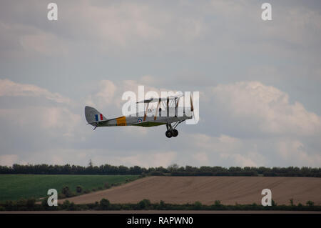 Small biplane flies over Duxford Imperial War Museum Stock Photo