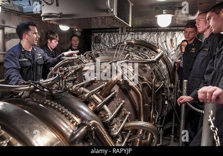 SOUTH CHINA SEA (March 3, 2017) Gas Turbine System Technician 2nd Class Andrew Mesenbrink (left), from Killen, Alabama, holds training on gas turbine modules during a tour of an engine room aboard Arleigh Burke-class guided-missile destroyer USS Wayne E. Meyer (DDG 108). Wayne E. Meyer is on a regularly scheduled Western Pacific deployment with the Carl Vinson Carrier Strike Group as part of the U.S. Pacific Fleet-led initiative to extend the command and control functions of U.S. 3rd Fleet into the Indo-Asia-Pacific region. U.S. Navy aircraft carrier strike groups have patrolled the Indo-Asia- Stock Photo