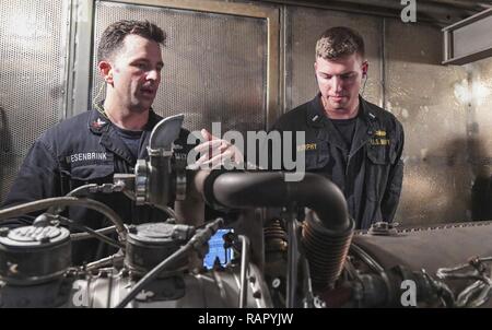 SOUTH CHINA SEA (March 3, 2017) Gas Turbine System Technician 2nd Class Andrew Mesenbrink (left), from Killen, Alabama, teaches Lt. j.g. Michael Murphy, from Indianapolis, Indiana, about gas turbine generators during a tour of an engine room aboard Arleigh Burke-class guided-missile destroyer USS Wayne E. Meyer (DDG 108). Wayne E. Meyer is on a regularly scheduled Western Pacific deployment with the Carl Vinson Carrier Strike Group as part of the U.S. Pacific Fleet-led initiative to extend the command and control functions of U.S. 3rd Fleet into the Indo-Asia-Pacific region. U.S. Navy aircraft Stock Photo