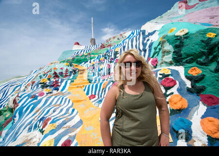 NILAND, CALIFORNIA - AUGUST 21 2018: Woman poses in front of Leonard Knights painted Salvation Mountain on Beal Road  outside of Niland, California Stock Photo