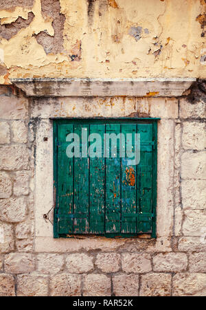 Green wooden  shutter in window on stone wall. Stock Photo