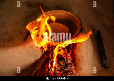 Traditional way of making food cooking on open fire using firewood in a rural village , near Kajiraho,India Stock Photo