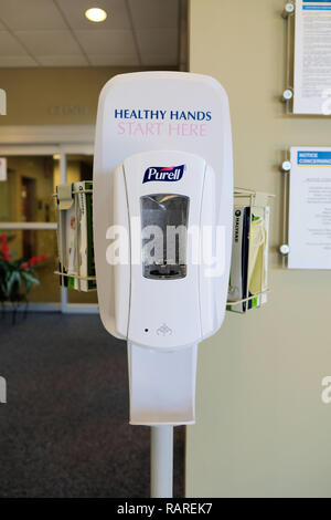 Purell hand sanitizer, antiseptic, and disinfectant dispenser at a medical building lobby; hospital antibacterial hand disinfectant. Stock Photo
