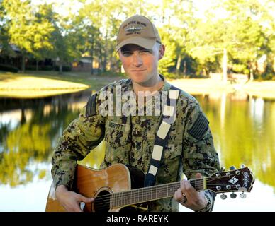 Machinist's Mate (Nuclear) 1st Class Hunter Merritt poses for a photo on Naval Submarine Base Kings Bay. A native of Denton, Georgia, Merritt, stationed aboard USS Rhode Island (Blue) (SSBN 740), is a singer/songwriter with a passion for music when he is not preparing for upcoming deployments and tactical exercises at sea. Rhode Island is one of five ballistic-missile submarines stationed at Naval Submarine Base Kings Bay, Ga. Stock Photo