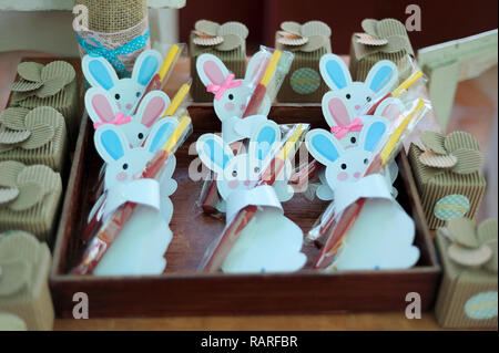 MERIDA, YUC/MEXICO - NOV 18, 2017: Twin babies's baptismal party venue decoration and gifts for guests. Rabbits holding bittersweets Stock Photo
