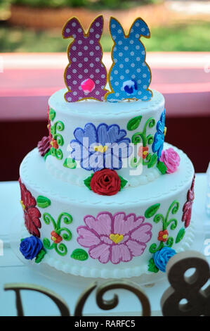 MERIDA, YUC/MEXICO - NOV 18, 2017: Twin babies's baptismal party venue decoration and gifts for guests. Cake with rabbits and flowers Stock Photo