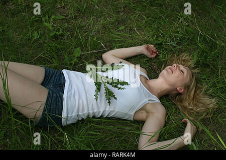 Woman lying on her back in the grass. Stock Photo