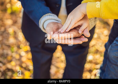 A child's hand holding the hand of an old man Stock Photo