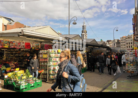 People passing by the floating Flower market on the canal ‘Singel’ in Amsterdam Center nearby the ‘Munttoren’ (Munt tower), the Netherlands Stock Photo