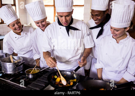 Group of chefs preparing food in kitchen Stock Photo