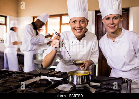 Two female chefs preparing food in kitchen Stock Photo