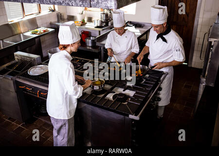 Group of chefs preparing food in kitchen Stock Photo