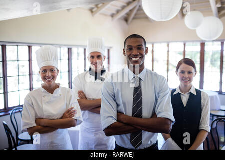 Group of hotel staffs standing with arms crossed in hotel Stock Photo