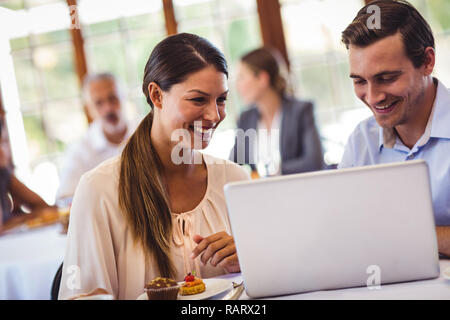 Couple discussing on laptop at table Stock Photo