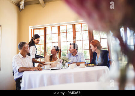 Waitress serving food on the table Stock Photo