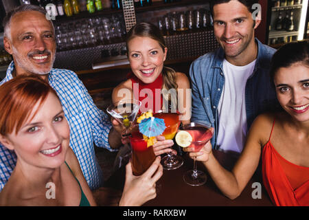 Friends toasting drink glasses in nightclub Stock Photo
