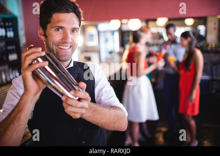 Bartender shaking cocktail mixer in nightclub Stock Photo