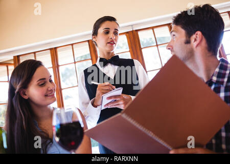 Waitress taking an order from a couple Stock Photo