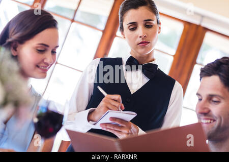 Waitress taking an order from a couple Stock Photo