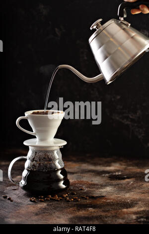 Making pour over coffee with hot water being poured from a kettle Stock Photo