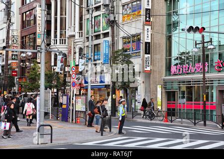 TOKYO, JAPAN - APRIL 12, 2012: People walk in Kanda-Surugadai district of Chiyoda ward in Tokyo, Japan. Tokyo is the capital city of Japan and the mos Stock Photo