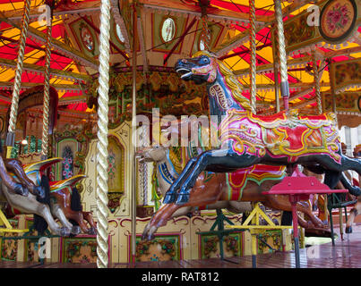 A close up of colourful carousel horses on a fairground amusement park merry go round Stock Photo